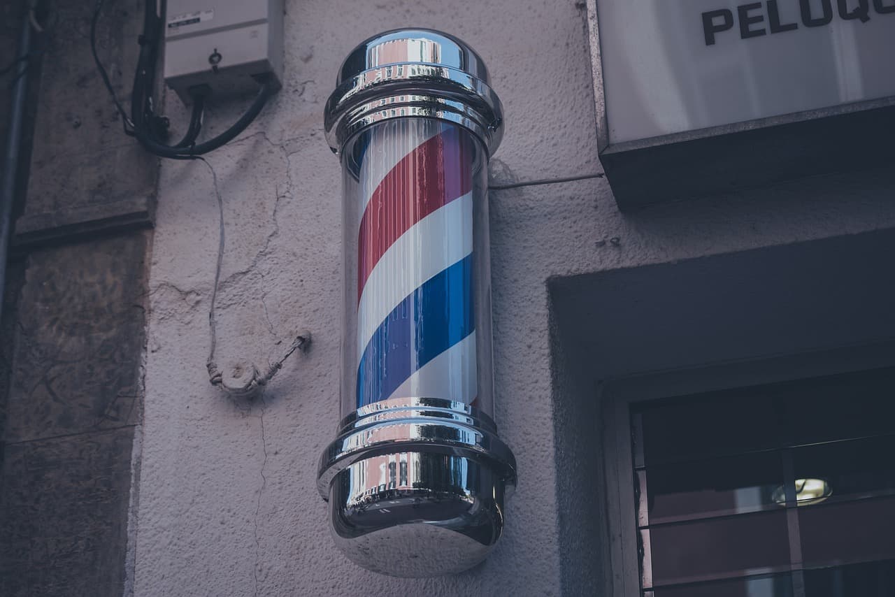 Red, white and blue barber pole on a dark wall