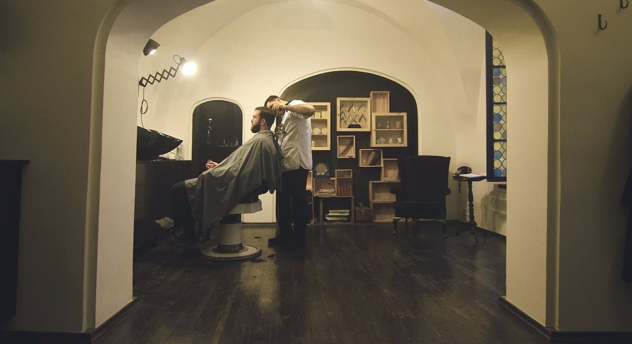 Warm, wood-panelled barber shop with a single chair under an arched ceiling