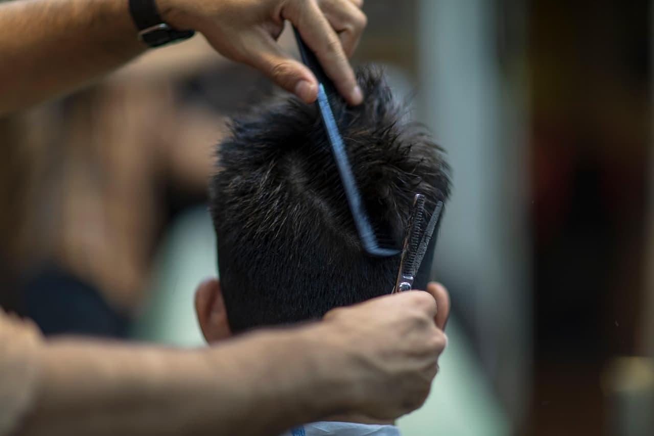 Comb and scissors shaping the top of a short cut